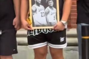 球迷手持詹姆斯和布朗尼的黑白画框合照在外滩等待